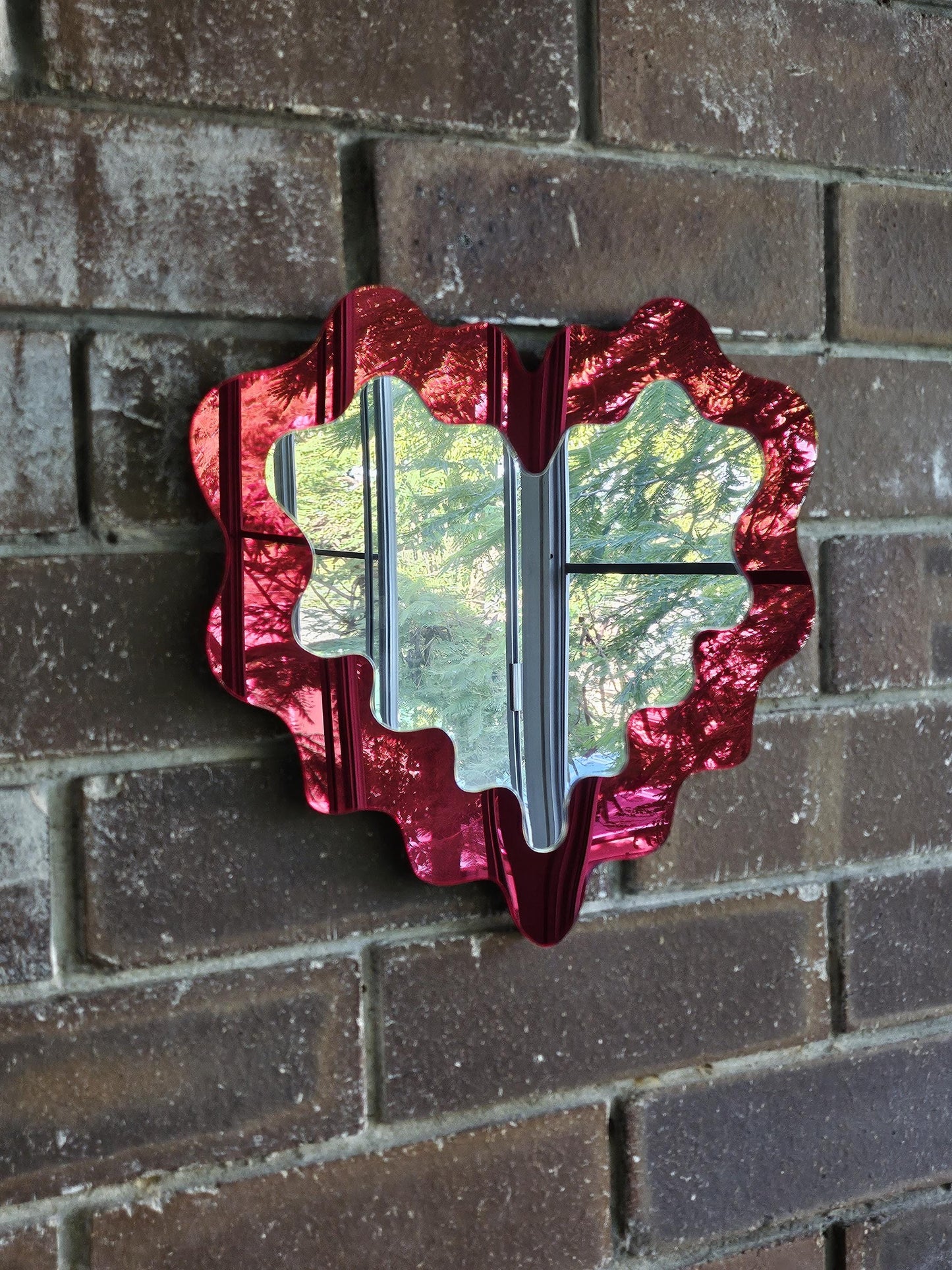 Red decorative mirror on a brick wall