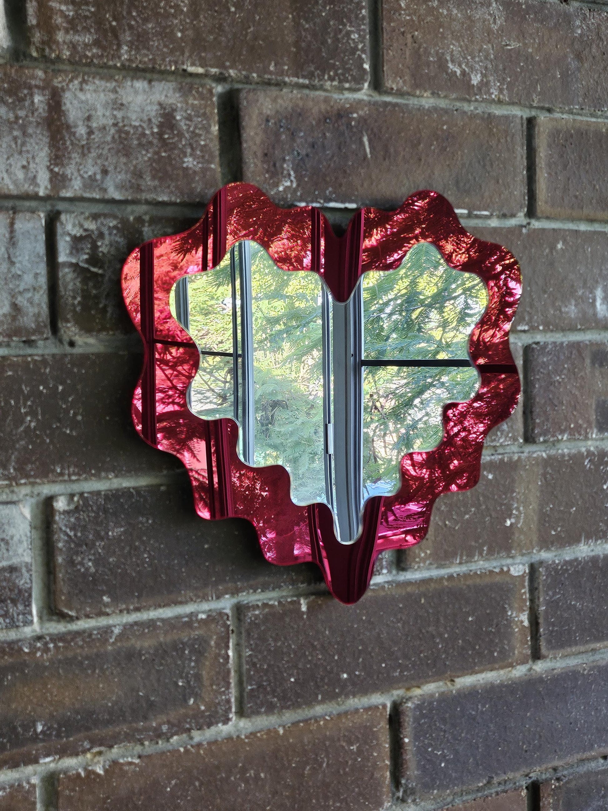 Red decorative mirror on a brick wall