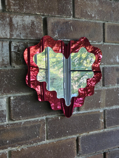 Red decorative mirror on a brick wall